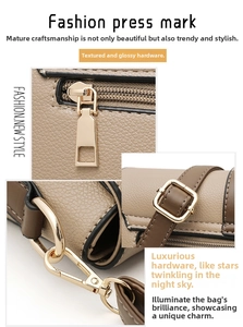 Detail of golden zipper and adjustable square buckle on brown litchi leather bag