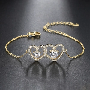 Adjustable gold bracelet with interlocking hearts and shimmering pave-set zircon stones