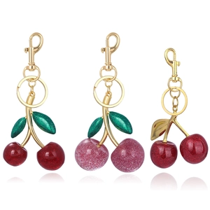 Macro detail of cherry resin keychains with glitter finish and gold lobster clasp
