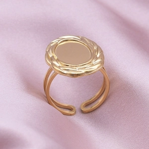 Close-up of golden geometric ring with braided rope border on purple silk background