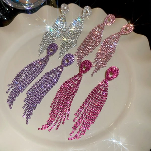 Detailed close-up of colorful rhinestone tassel earrings in silver and pink tones