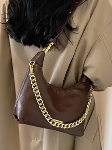 Brown quilted crossbody bucket bag with gold chain strap shown on a model