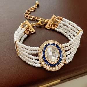 Detail of multi-layer pearl bracelet with blue enamel gemstone and crystal inlay