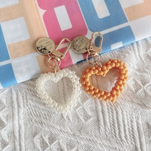 Handmade pearl heart keychains in white and orange with gold metal charms