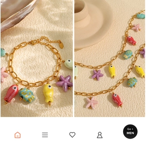 Detailed shot of golden necklace and bracelet set with colorful ceramic sea fish charms