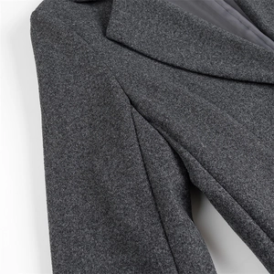 Detail shot of charcoal gray wool coat showing neck stitching and premium fabric texture