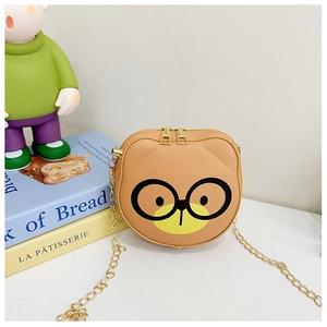 Detail of yellow cartoon bear crossbody bag showing dual zippers and golden chain strap