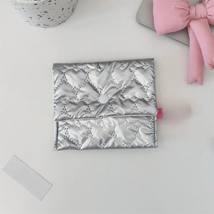 Close-up of heart-quilted silver pouch with pink lanyard on a clean aesthetic background