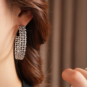 Close-up of silver-tone chunky hollow C-shaped hoop earrings with a textured mesh design