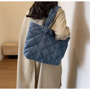 Détail du grand sac cabas en jean matelassé bleu avec motif à losanges et bandoulière