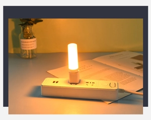 Close-up of a USB LED night light with warm dynamic flame effect glowing on a power strip