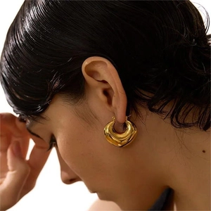French vintage thick 18K gold plated stainless steel hoop earrings worn by a model