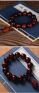 Macro detail of red sandalwood beads with carved Buddha pendant on a vintage book
