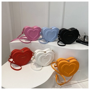 Collection of quilted heart shaped crossbody bags in six vibrant colors on display stand