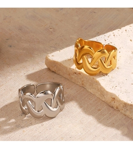 Detail of gold and silver textured braided rings displayed on elegant beige stone