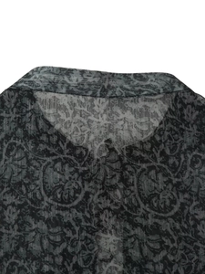 Detail of the vintage circular print and breathable textured fabric on the grey shirt collar