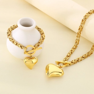 Detail of gold hollow heart pendant and toggle clasp on Byzantine chain jewelry set