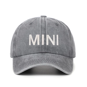 Close-up of white MINI embroidery on vintage washed grey cotton baseball cap for kids