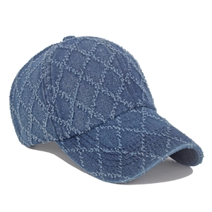 Gros plan d'une casquette en denim bleu foncé avec texture effilochée à losanges