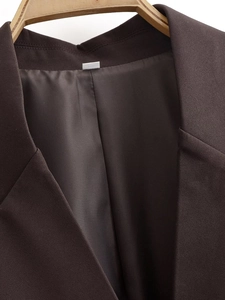 Detail of dark brown blazer collar with fine texture and smooth silk lining on hanger