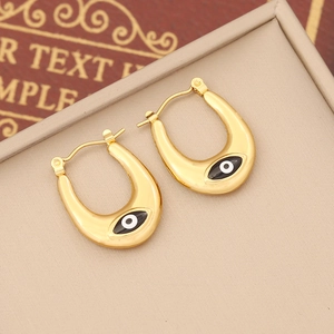 Macro shot of gold horseshoe evil eye earrings in a beige velvet jewelry display box