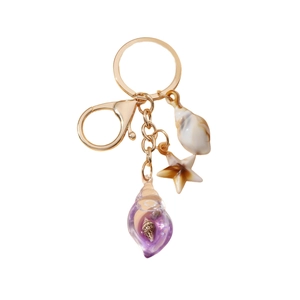 Luminous starfish and shell keychain with purple glass snail pendant on white background