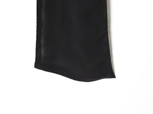 Close-up of fine stitching on black georgette fabric and semi-transparent hem detail