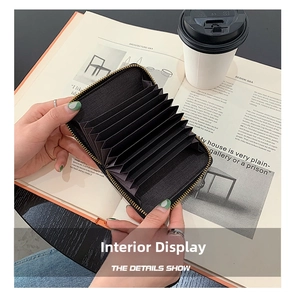 Detailed view of black multi-slot card holder with gold zipper and accordion style design