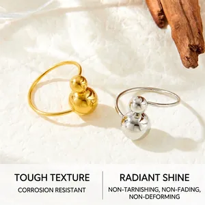 Close-up of gold and silver minimalist double ball rings on a textured background