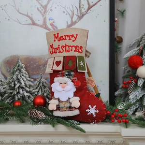 Detail of hanging Christmas stocking with Santa Claus doll and festive fireplace decor