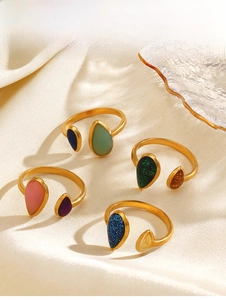 Macro shot of colorful teardrop oil-drop adjustable steel rings on white silk
