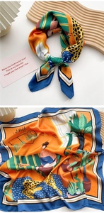 Detailed view of square silk scarf with leopard print and tropical plant patterns