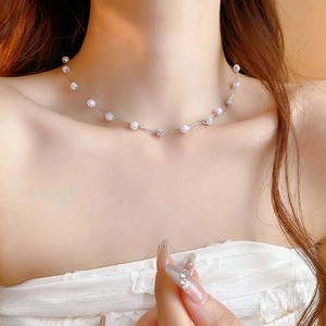 Close-up of double-layer necklace with white pearls and sparkling pavé crystal spheres