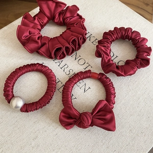 Set of four burgundy satin scrunchies featuring pearl detail and elegant bow ornaments