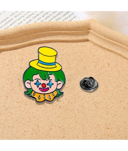 Detail einer lustigen Emaille-Anstecknadel mit Clown-Motiv auf strukturiertem Tablett