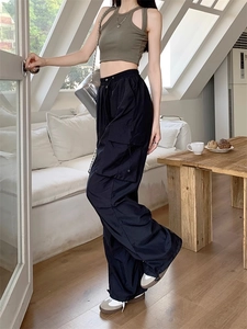 Detail view of high-waist black cargo pants with large pockets in a cozy indoor setting