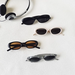 Set of four vintage oval sunglasses in black, white, tortoiseshell, and grey colors