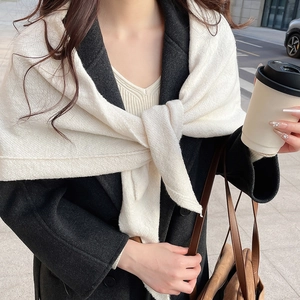 Gros plan d'un châle en tricot blanc côtelé porté sur un manteau gris élégant en hiver