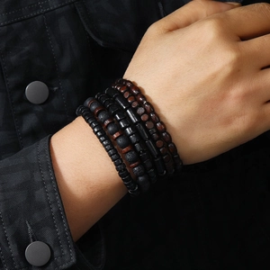 Close-up of men's multilayer beaded bracelet featuring dark wood and coconut shell beads