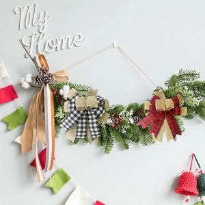 Detail of red and white buffalo plaid Christmas bows on a decorative pine garland
