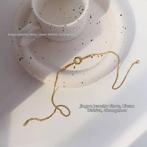 Close-up of 18K gold-plated chain necklace with a lobster clasp and round pendant