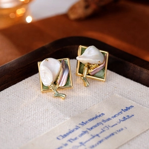 Boucles d'oreilles tulipes en perles baroques et émail vert sur fond esthétique rustique