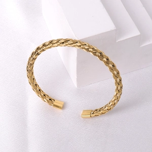 Detailed view of golden woven titanium steel bangle with polished rectangular ends