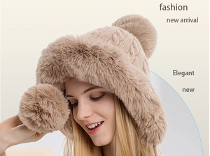 Close-up of knit winter hat with thick faux fur lining and three decorative pom-poms