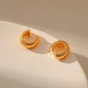 Chunky 18K gold plated hoop earrings with textured ribbed design on stone tray