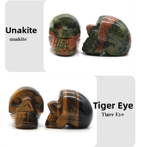 Detail view of hand-carved natural Unakite and Tiger Eye crystal skull ornaments