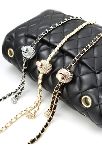 Close-up of metal chain straps with rhinestone adjustment balls for crossbody bags