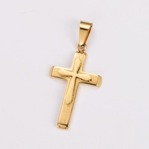 Macro detail of a golden cross pendant with intricate textured engravings on white background