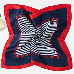Detailed flat lay of a silk square scarf with red and blue geometric patchwork design