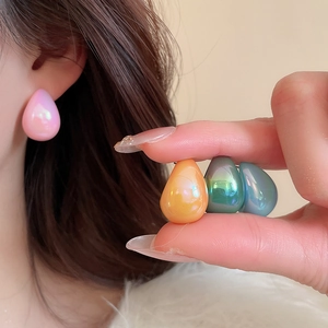 Detailed view of colorful iridescent teardrop earrings in pink, orange, green and blue